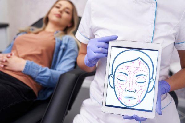 Doctor,Presenting,Digital,Tablet,With,Face,Lifting,Sketch